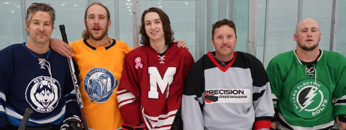 Five hockey players wearing different team jerseys